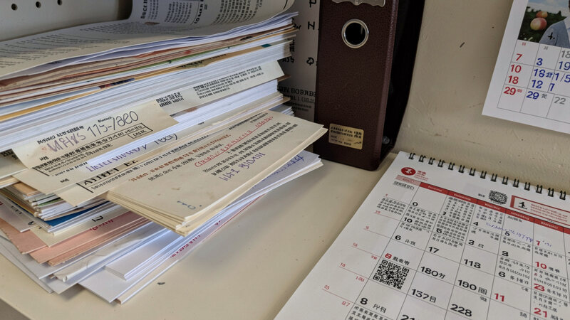 A kitchen table in daylight, a printed hospital statement covered in handwritten notes and a pen resting on it, shot from slightly above at a close angle.